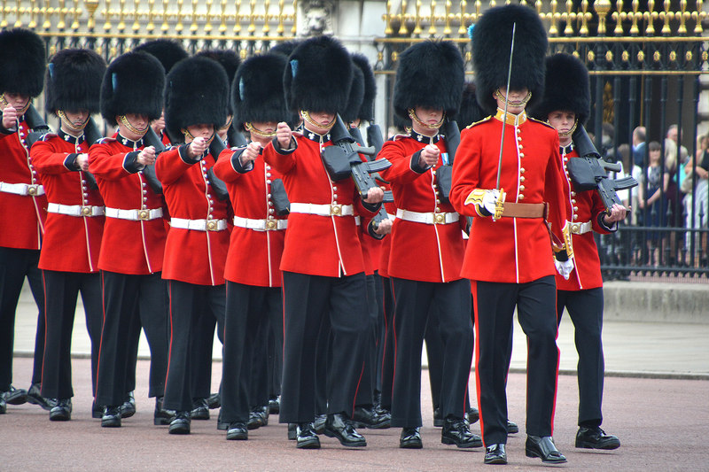 A marching group of Grenadier Guards outside Buckingham Palace.