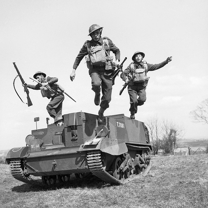 British troops leap from their Universal Carrier during an exercise.