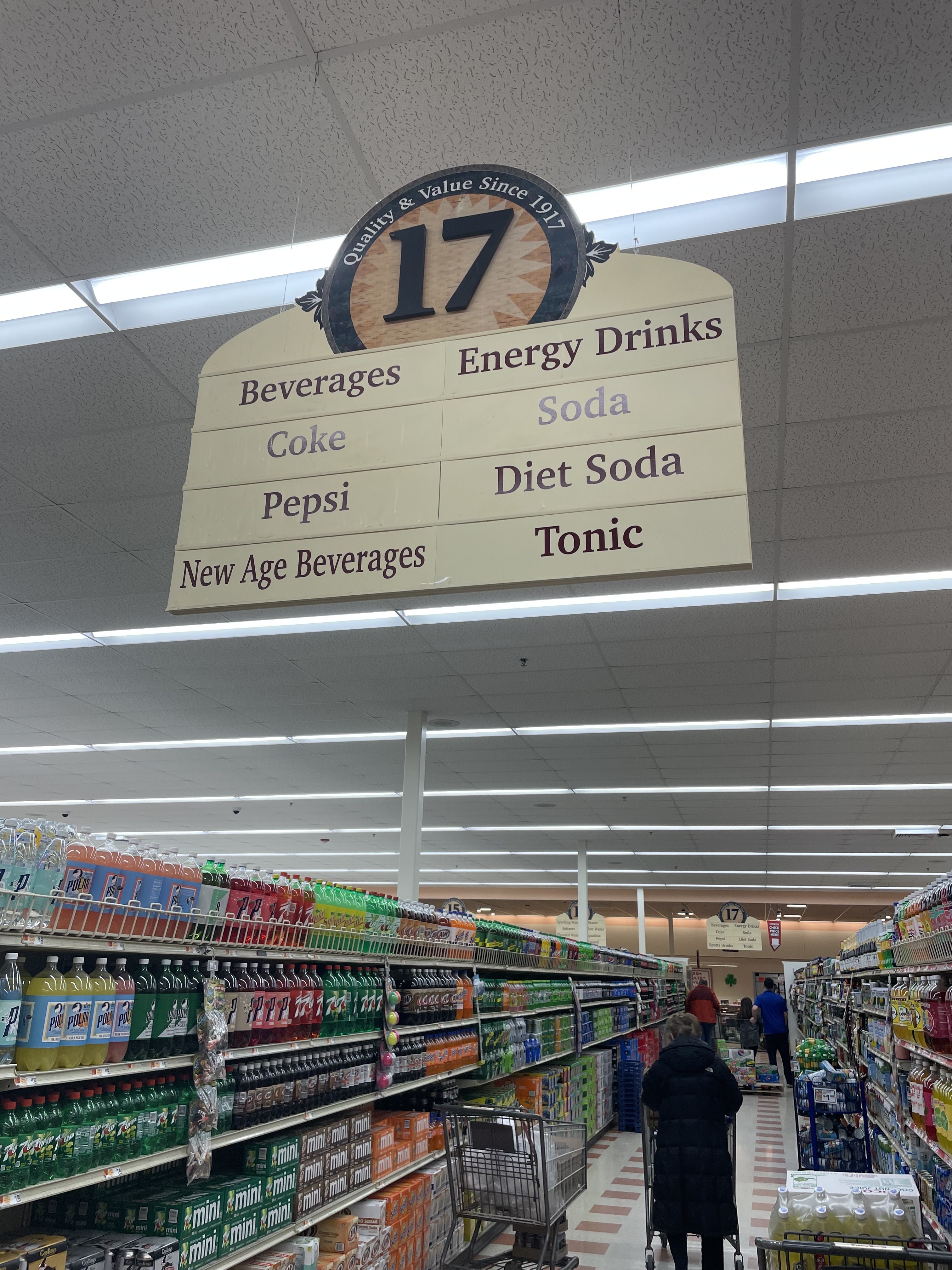 A grocery store aisle sign advertising New Age Beverages.